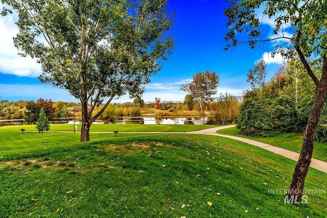 view of property's community with a lawn and a water view