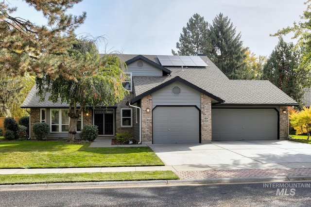 view of front facade with a garage, a front lawn, and solar panels