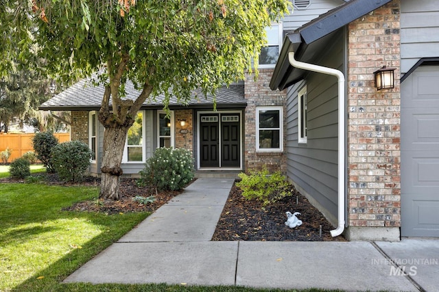 entrance to property featuring a lawn