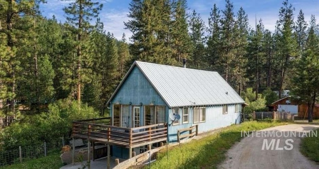 rear view of house with a deck and metal roof