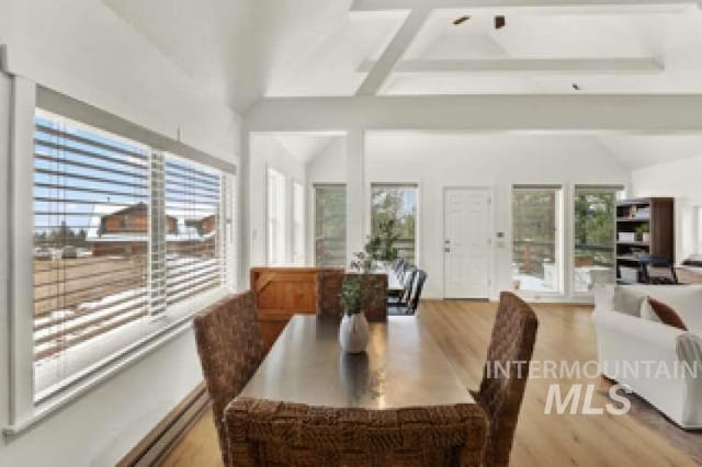 dining space with lofted ceiling with beams and light wood-type flooring