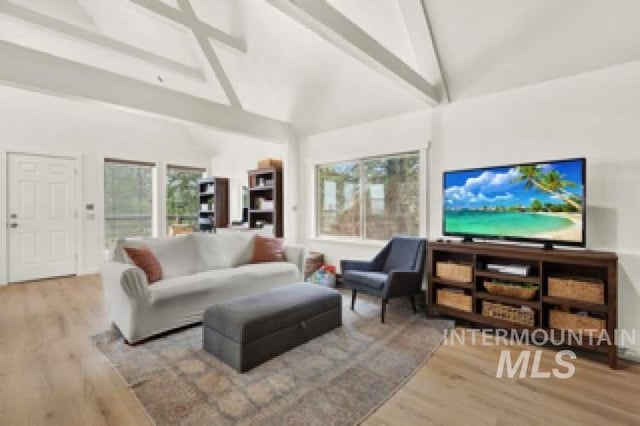 living room featuring high vaulted ceiling, beam ceiling, and light hardwood / wood-style flooring