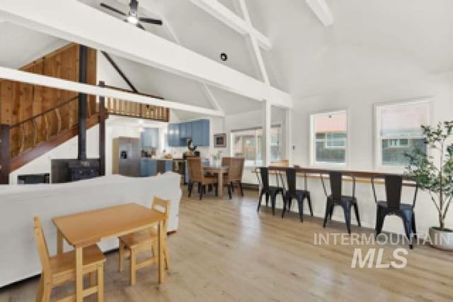 dining area with high vaulted ceiling, hardwood / wood-style floors, and beam ceiling