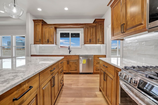 kitchen featuring appliances with stainless steel finishes, brown cabinets, and a sink