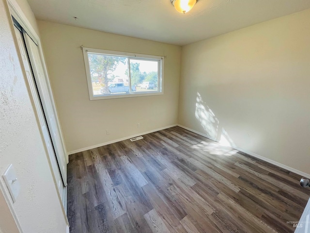 unfurnished bedroom featuring dark wood-type flooring and a closet