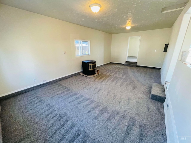 empty room featuring dark carpet and a textured ceiling