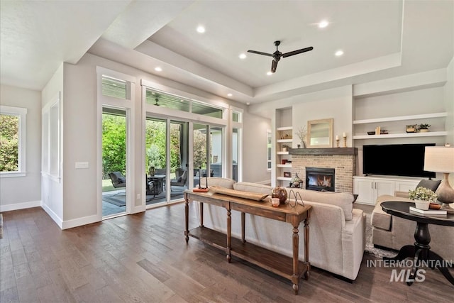 2165 N Luge Ave, Eagle, ID 83616 - living area with a tray ceiling, ceiling fan, baseboards, a fireplace, and built in shelves