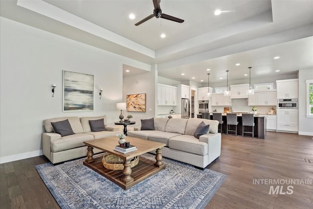2165 N Luge Ave, Eagle, ID 83616 - living room featuring dark wood-style floors, a ceiling fan, baseboards, recessed lighting, and a tray ceiling