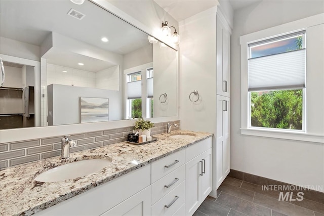 2165 N Luge Ave, Eagle, ID 83616 - full bathroom featuring double vanity, healthy amount of natural light, tile patterned flooring, tasteful backsplash, and recessed lighting