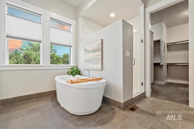 2165 N Luge Ave, Eagle, ID 83616 - full bath featuring a shower stall, baseboards, a spacious closet, a freestanding bath, and tile patterned floors
