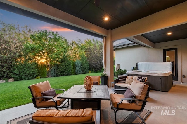 2165 N Luge Ave, Eagle, ID 83616 - patio terrace at dusk with a hot tub, a patio, a lawn, outdoor lounge area, and a garage