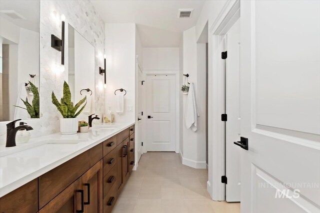 full bathroom featuring double vanity, visible vents, tile patterned flooring, and a sink