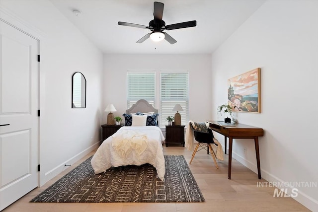 bedroom featuring light wood finished floors, baseboards, and a ceiling fan