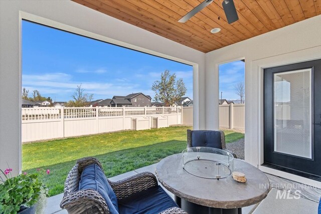 exterior space featuring fence, ceiling fan, outdoor dining area, and a residential view