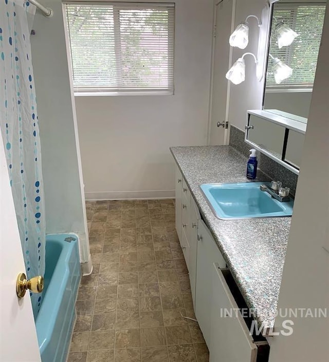 bathroom with plenty of natural light, vanity, and shower / tub combo with curtain