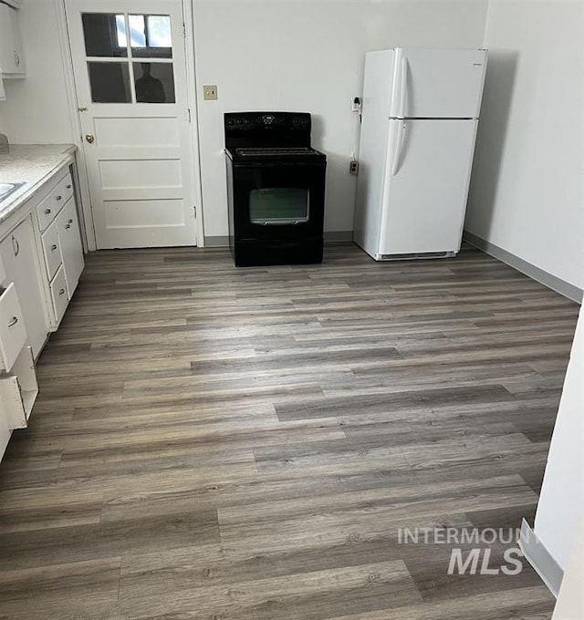 kitchen with electric range, white cabinets, light wood-type flooring, and white refrigerator