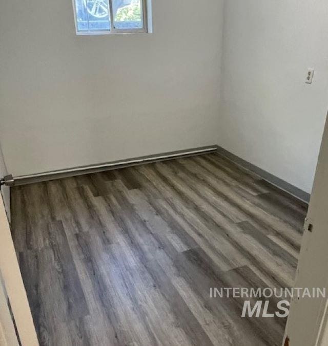 unfurnished room with dark hardwood / wood-style flooring