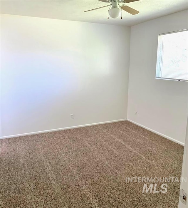 carpeted spare room with ceiling fan