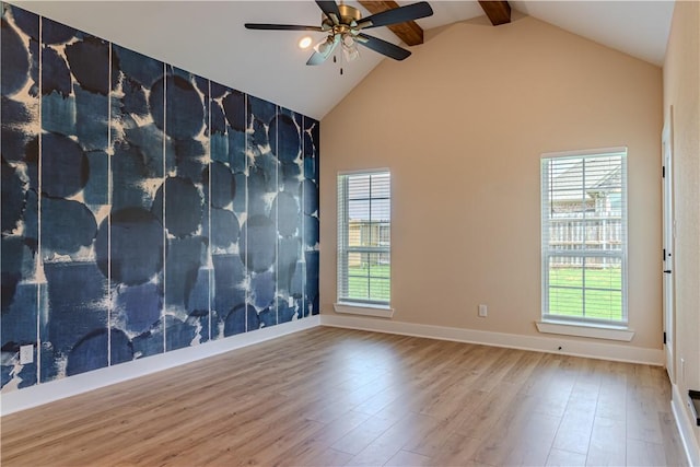 empty room featuring ceiling fan, high vaulted ceiling, beam ceiling, and hardwood / wood-style floors