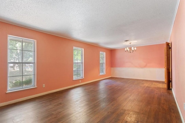 spare room with dark hardwood / wood-style flooring, a healthy amount of sunlight, and a textured ceiling