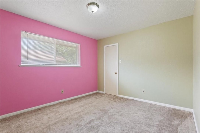 carpeted empty room with a textured ceiling