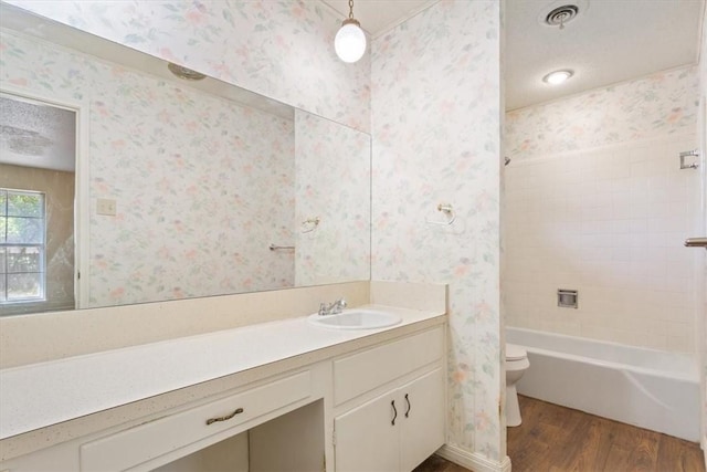 full bathroom featuring vanity, hardwood / wood-style flooring, toilet, and  shower combination