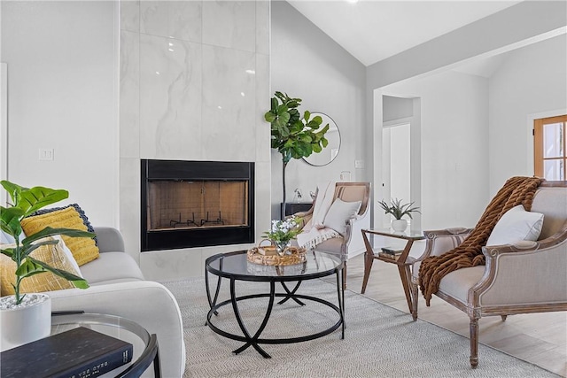 living area featuring a fireplace, hardwood / wood-style floors, and vaulted ceiling