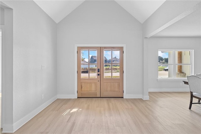 foyer entrance featuring vaulted ceiling, french doors, and plenty of natural light