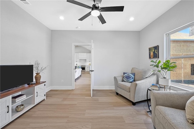 living room featuring light wood-type flooring and ceiling fan