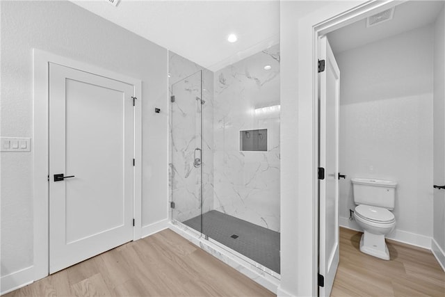 bathroom with walk in shower, wood-type flooring, and toilet