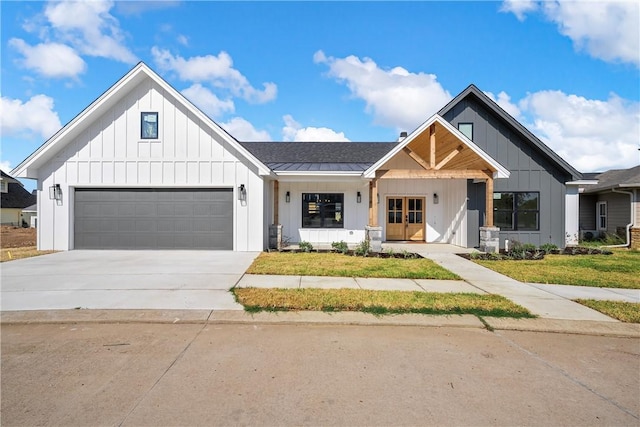 modern inspired farmhouse with covered porch, a garage, and french doors