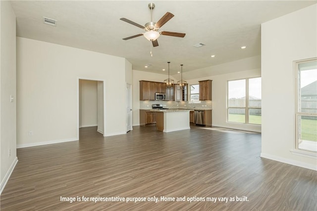 unfurnished living room featuring ceiling fan and dark wood-type flooring