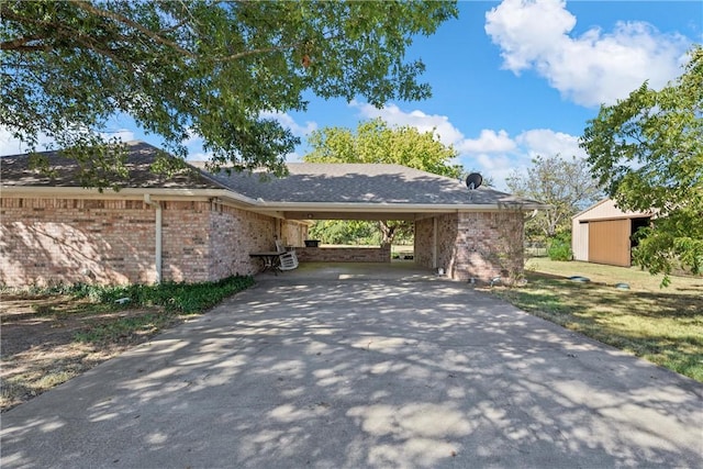 exterior space featuring an attached carport, driveway, and a storage shed