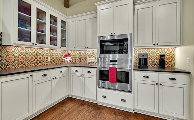 kitchen with decorative backsplash, dark hardwood / wood-style flooring, and stainless steel double oven