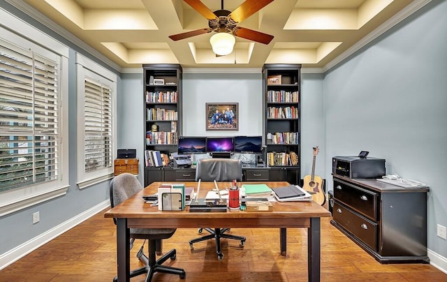 office featuring ornamental molding, coffered ceiling, a raised ceiling, ceiling fan, and light hardwood / wood-style flooring