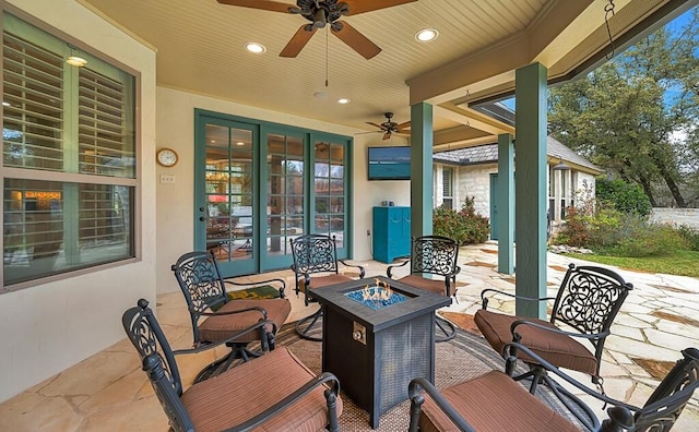 view of patio / terrace with ceiling fan and an outdoor living space with a fire pit