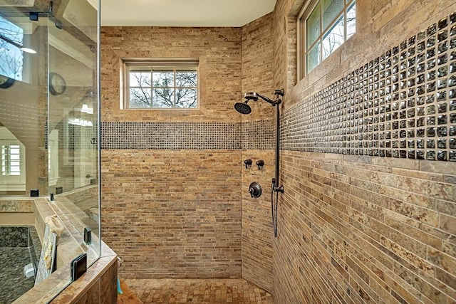 bathroom featuring tiled shower and a healthy amount of sunlight