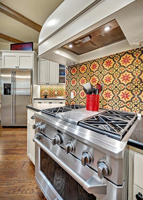 kitchen featuring white cabinets, premium appliances, premium range hood, and dark hardwood / wood-style floors