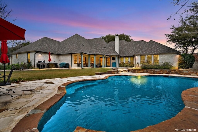 pool at dusk featuring a yard and a patio