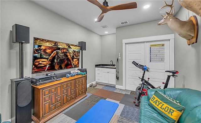 workout area with ceiling fan and sink