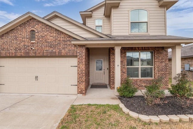 view of front of property with concrete driveway, an attached garage, and brick siding