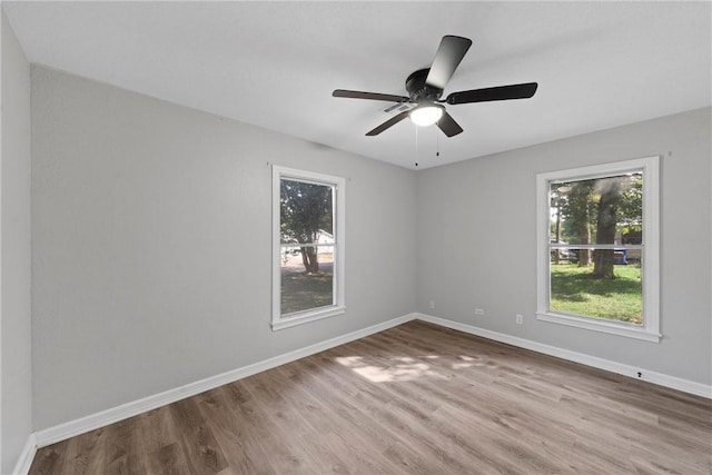 unfurnished room featuring hardwood / wood-style floors, plenty of natural light, and ceiling fan