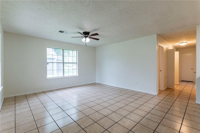 tiled empty room featuring ceiling fan and a textured ceiling