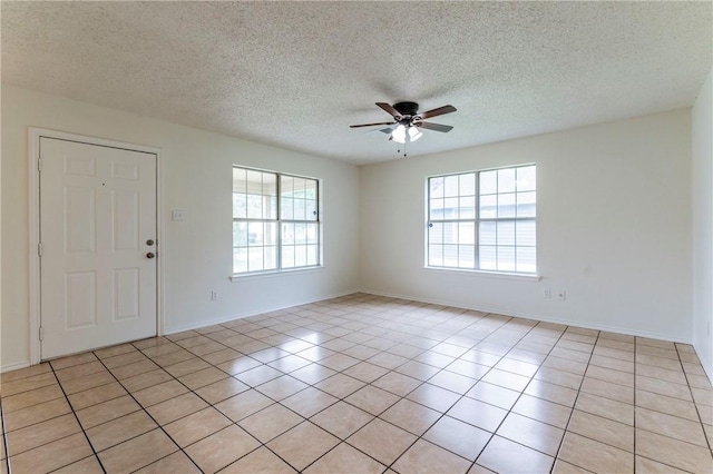 tiled entryway with ceiling fan and a textured ceiling