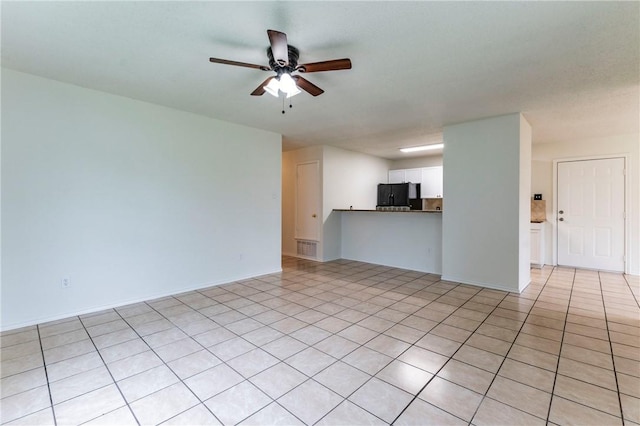 unfurnished living room featuring ceiling fan and light tile patterned floors