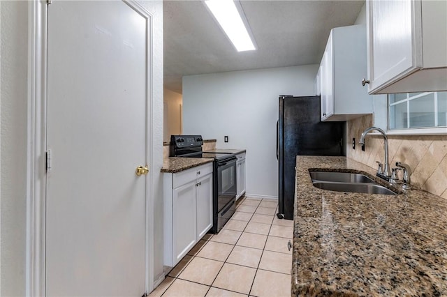 kitchen featuring tasteful backsplash, sink, black appliances, dark stone countertops, and white cabinets