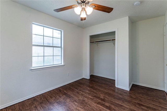 unfurnished bedroom with ceiling fan, dark hardwood / wood-style flooring, a textured ceiling, and a closet