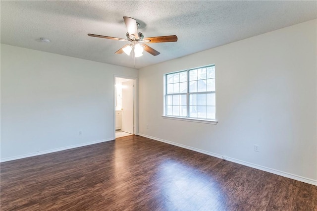 spare room featuring ceiling fan, dark wood-type flooring, and a textured ceiling