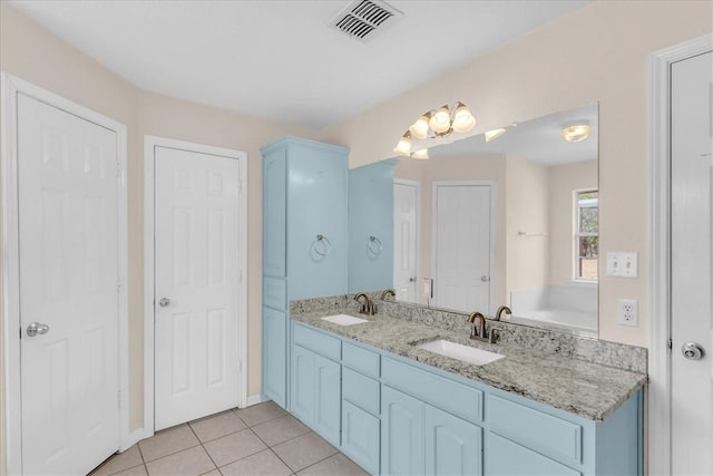 bathroom featuring tile patterned floors, a bathtub, and vanity