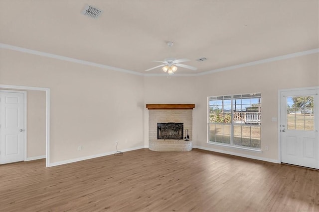 unfurnished living room featuring a fireplace, hardwood / wood-style flooring, ceiling fan, and crown molding